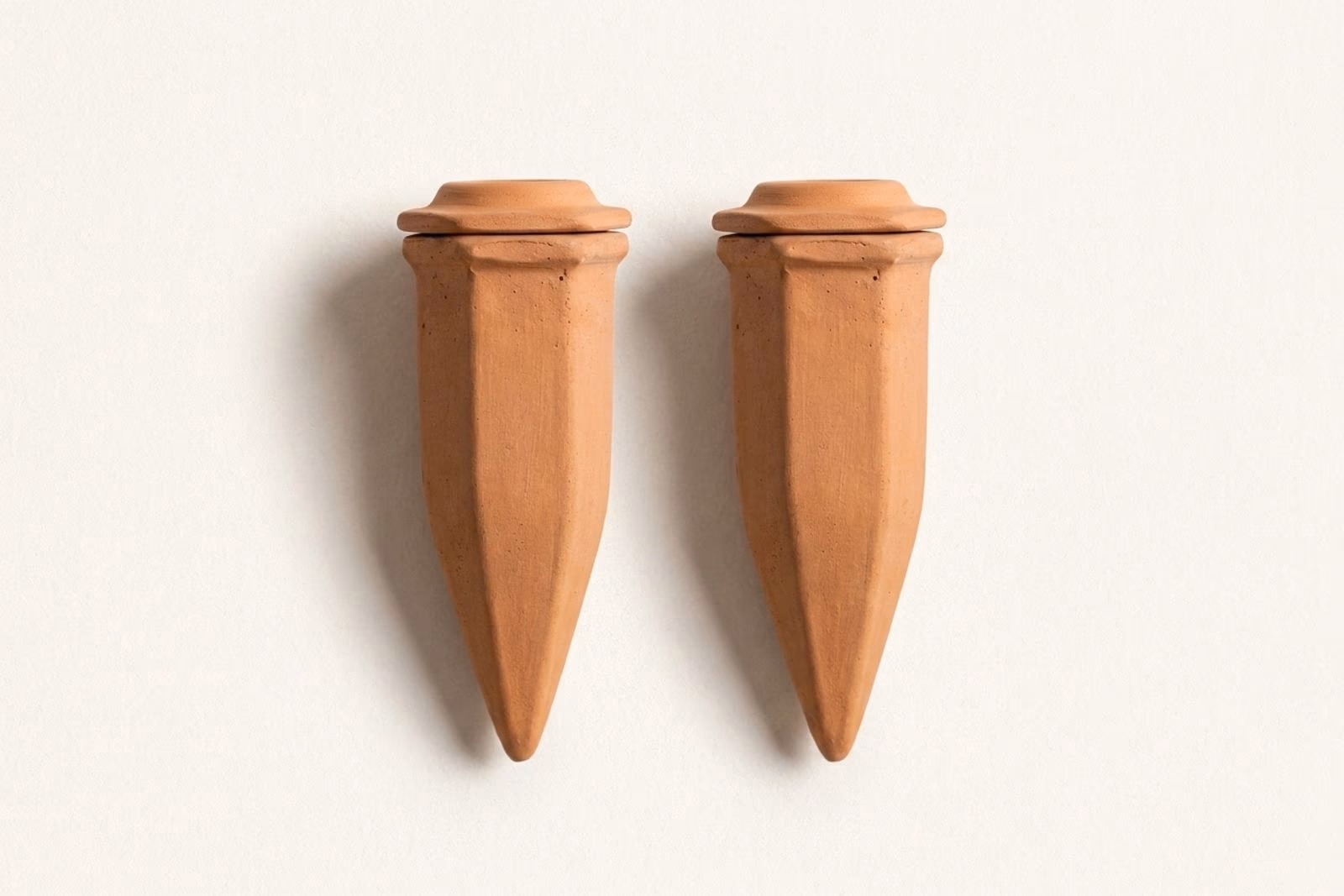 Oya en terre cuite entiere posee debout avec son couvercle terracotta pose dessus, fond studio off-white avec ombre douce