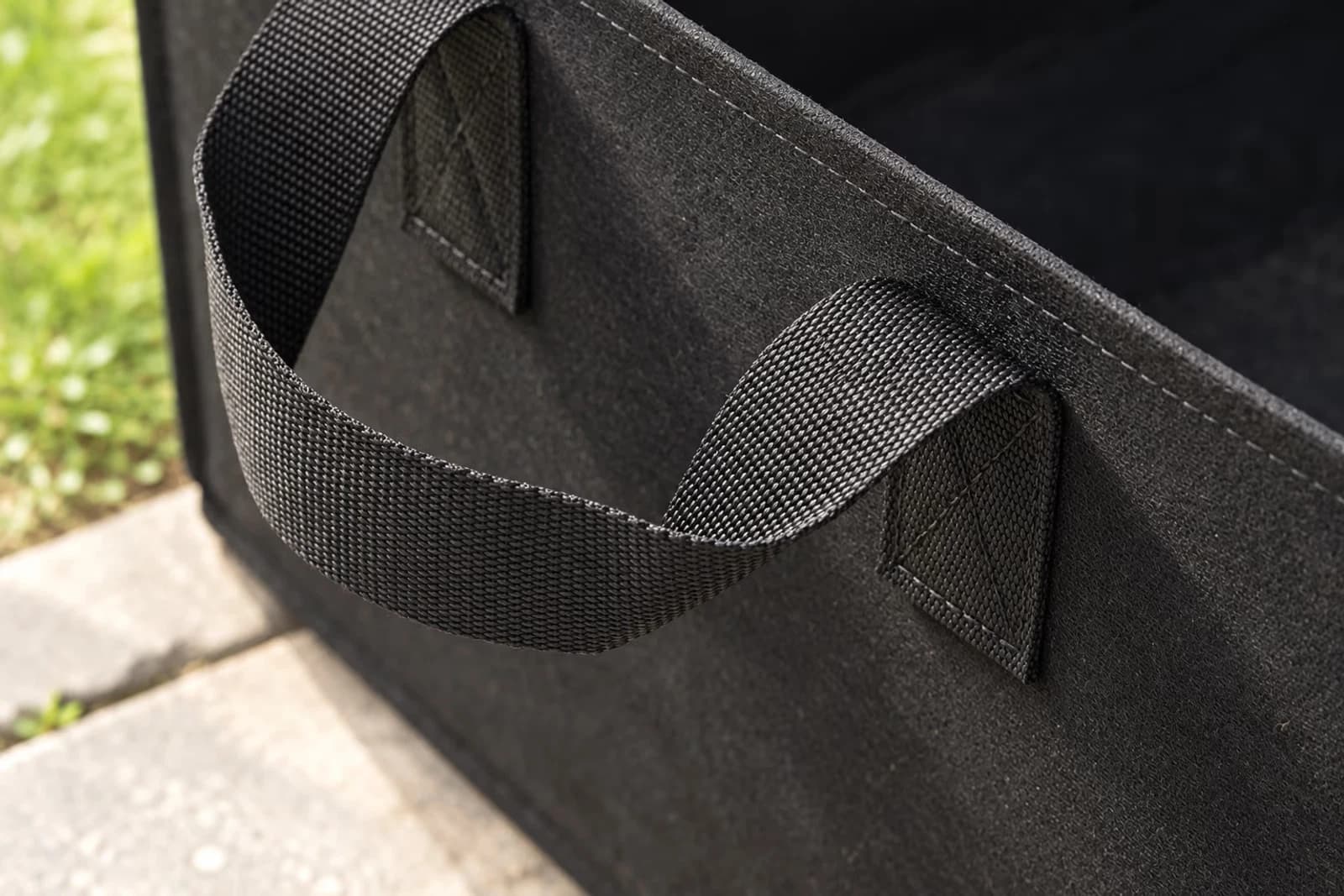 Macro sur une poignée laterale en sangle nylon noire avec couture double renforcee sur le tissu geotextile