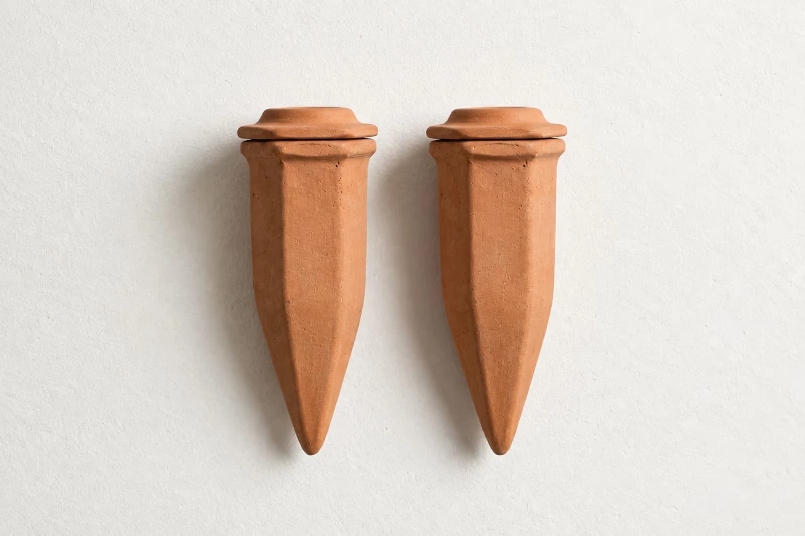 Oya en terre cuite entiere posee debout avec son couvercle terracotta pose dessus, fond studio off-white avec ombre douce
