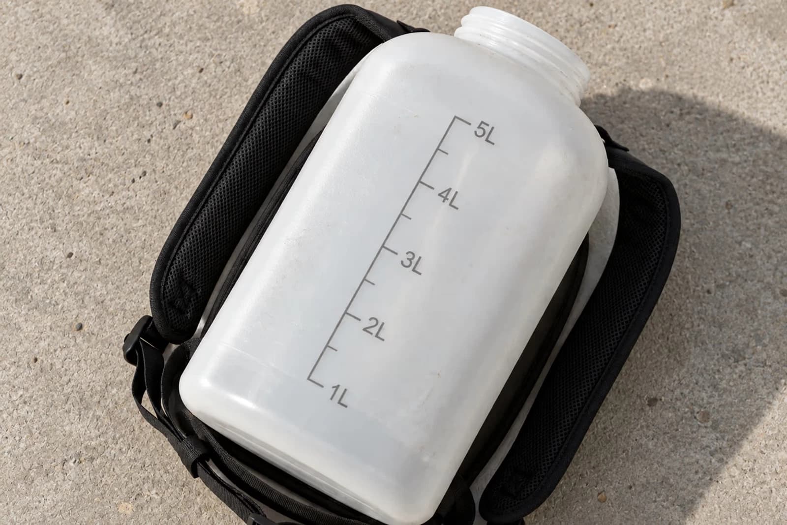 Top-down du reservoir translucide 5L gradue litre par litre, sangles dorsales matelassees noires visibles