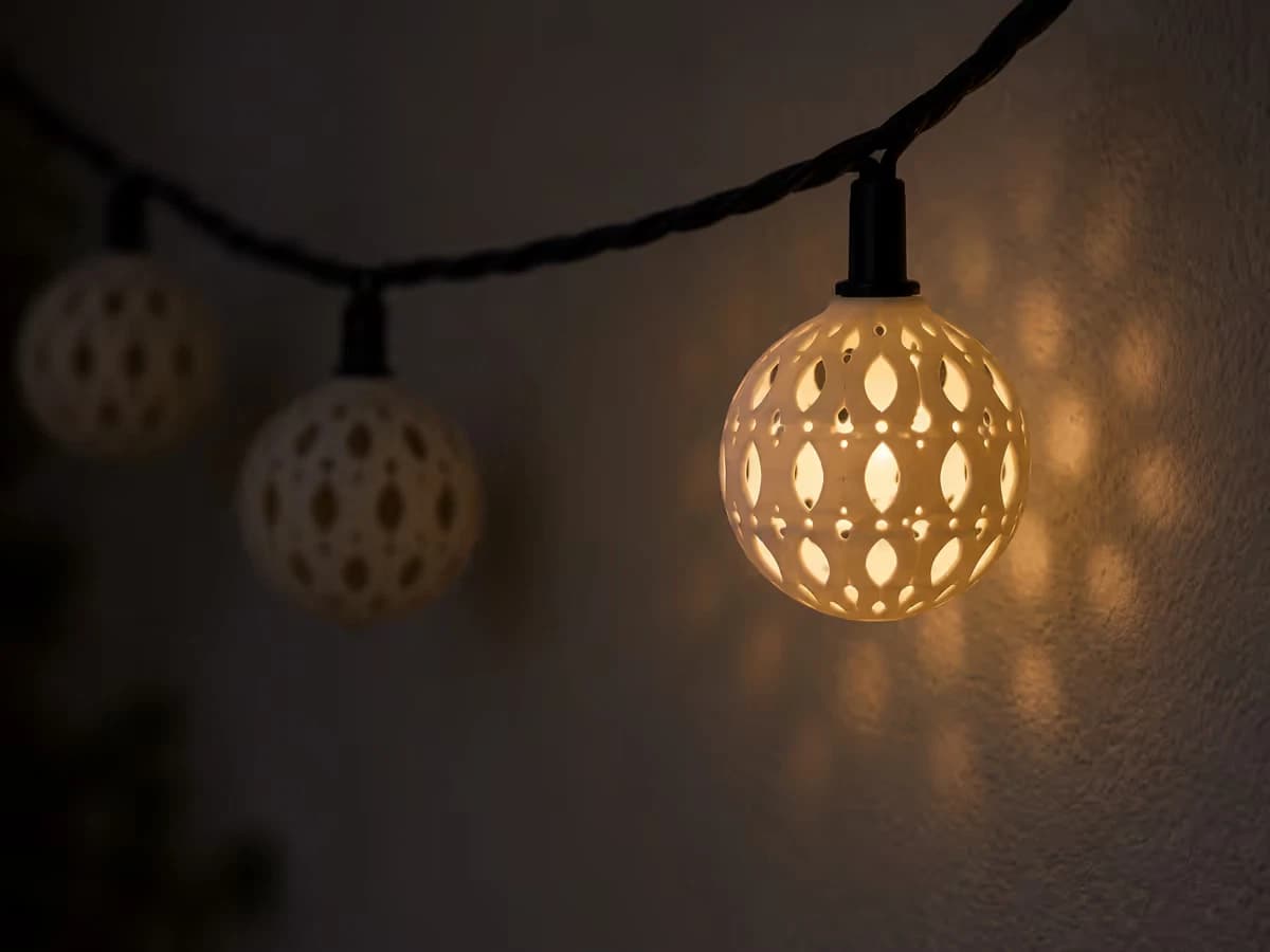 Ombres portées d'une boule marocaine lumineuse sur un mur crépi blanc