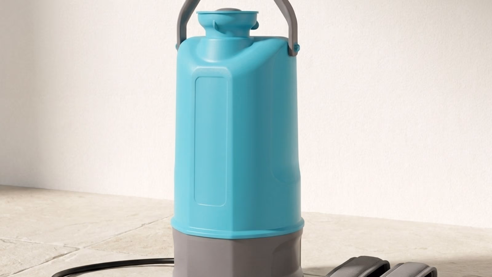 Pulvérisateur électrique 5L à dos Jarditips posé sur dalle pierre claire, lance télescopique aluminium déployée