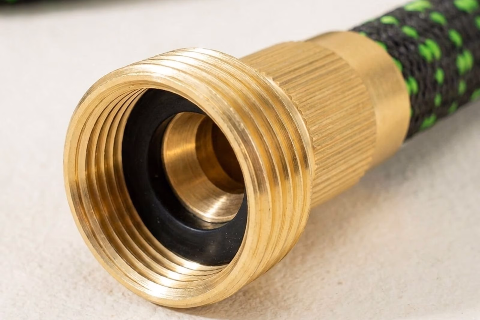 Macro raccord laiton massif 3/4 pouce du tuyau extensible, filetage visible, joint EPDM noir interieur, fond studio doux