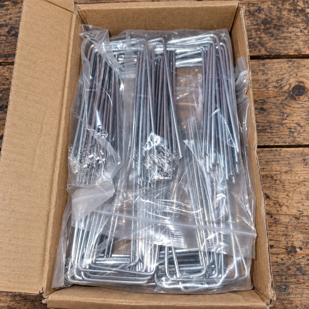 Carton ouvert et sachet transparent rempli de cent agrafes