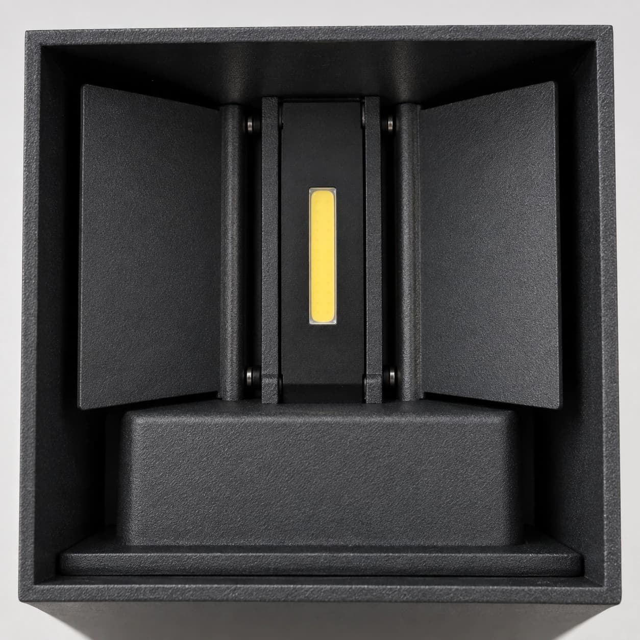 L'intérieur du boîtier noir : platine centrale, bande LED jaune et deux volets orientables