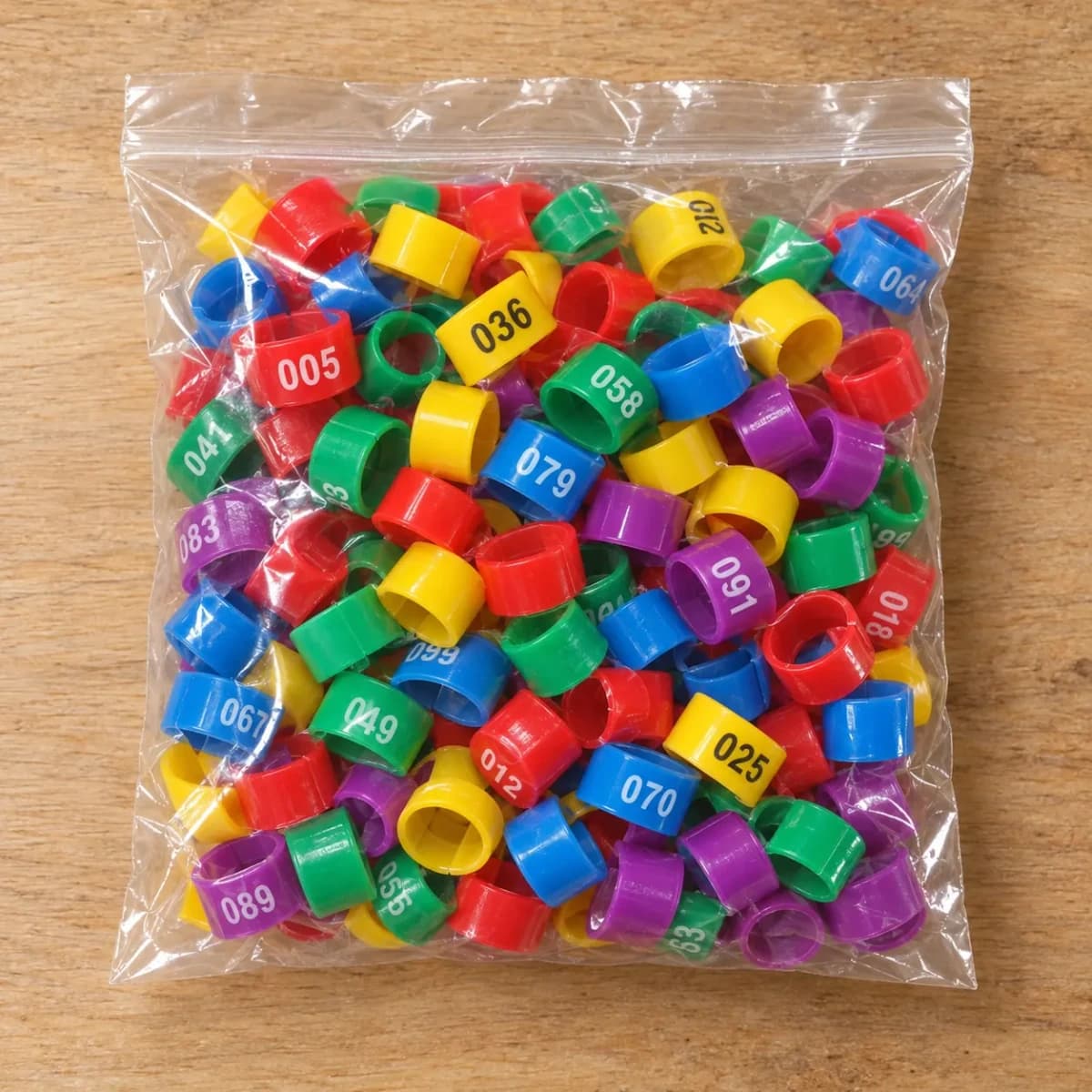 Le sachet transparent du colis refermé, rempli des cent bagues numérotées en cinq couleurs