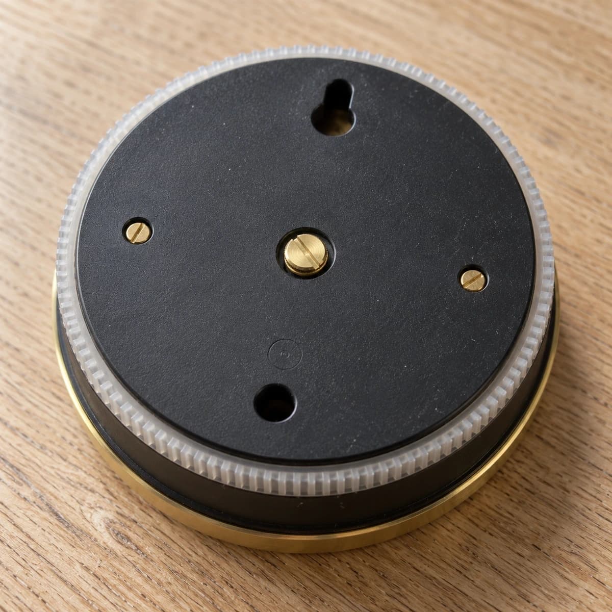 Dos du baromètre : platine noire mate, vis de réglage en laiton doré et ouverture de suspension