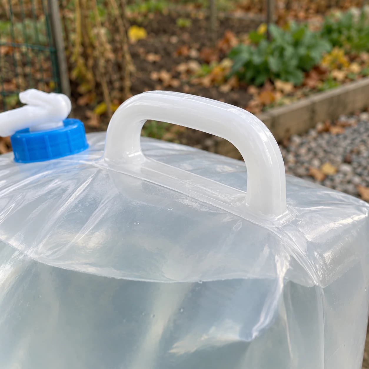 Gros plan de la poignée rigide soudée dans la couture du dessus, niveau d'eau lisible sous la paroi translucide