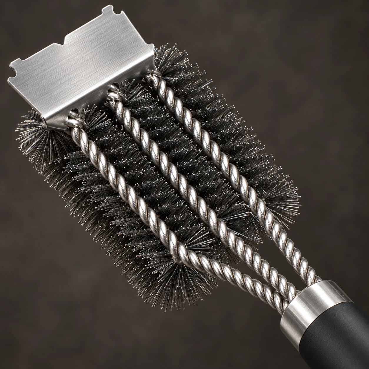 Détail des trois cordes inox torsadées et des rangs de poils d'acier serrés de la brosse à gril