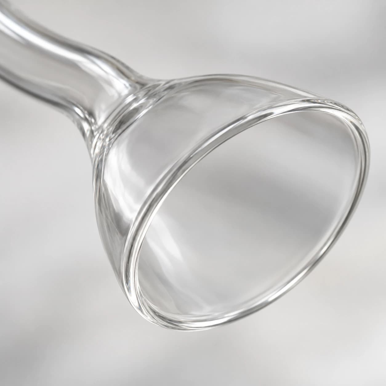 Gros plan sur l’embouchure évasée : lèvre polie et ouverture ovale du verre mince