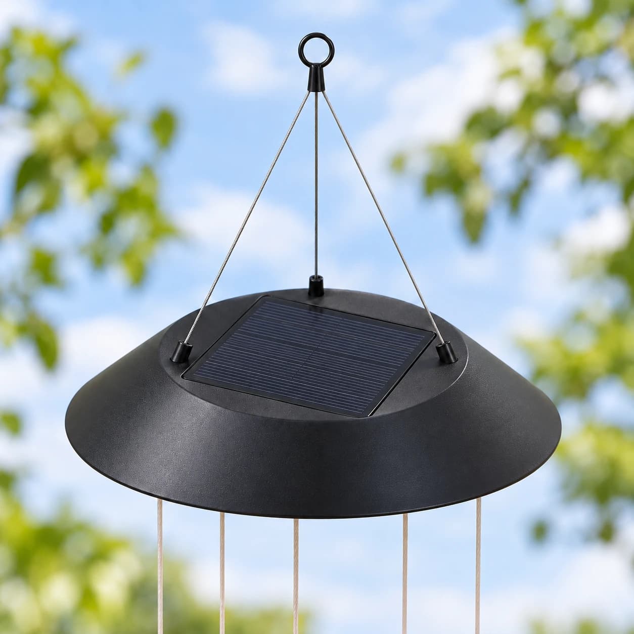 Le dessus du cône noir du carillon et son panneau solaire carré, anneau et fils de suspension
