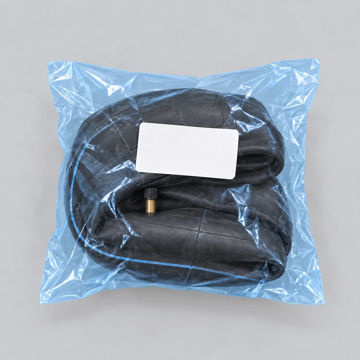 La chambre pliée seule dans le sachet bleu translucide, l'étiquette blanche du colis visible