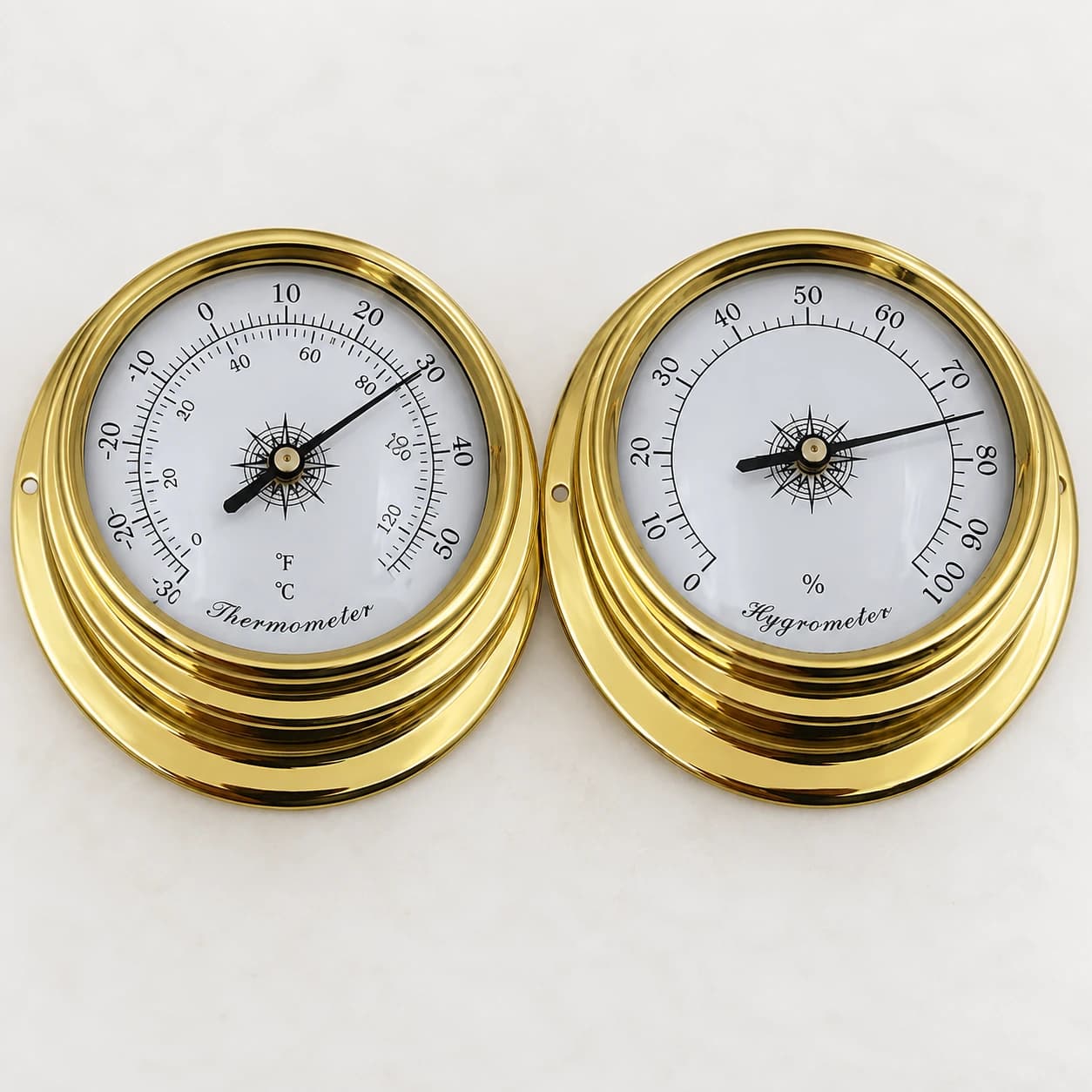Gros plan du thermomètre doré, échelle de moins 30 à plus 50 degrés, aiguille noire et moyeu en étoile
