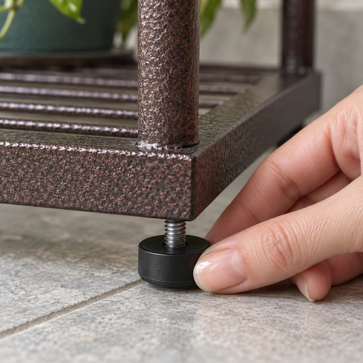 Détail des pieds réglables noirs et de l'assemblage des montants de la colonne à plantes en métal