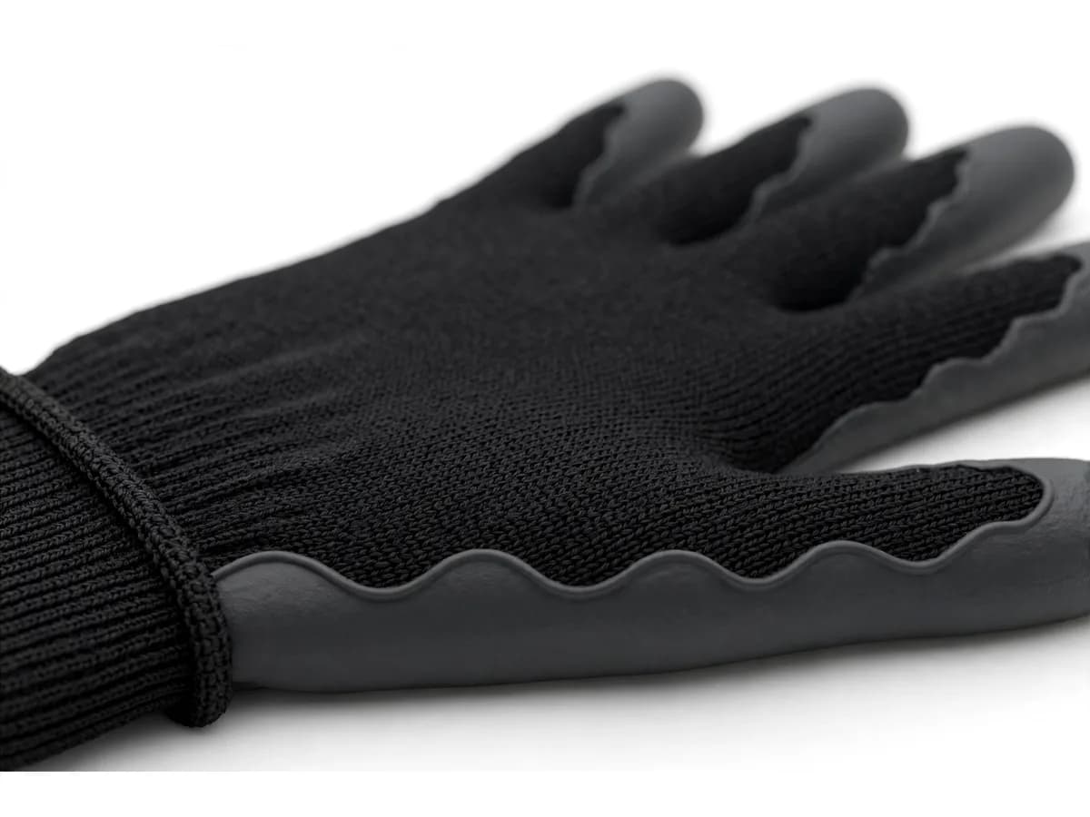 Macro de la finition, frange festonnée où l'enduction de paume s'arrête sur le tricot du dos de la main