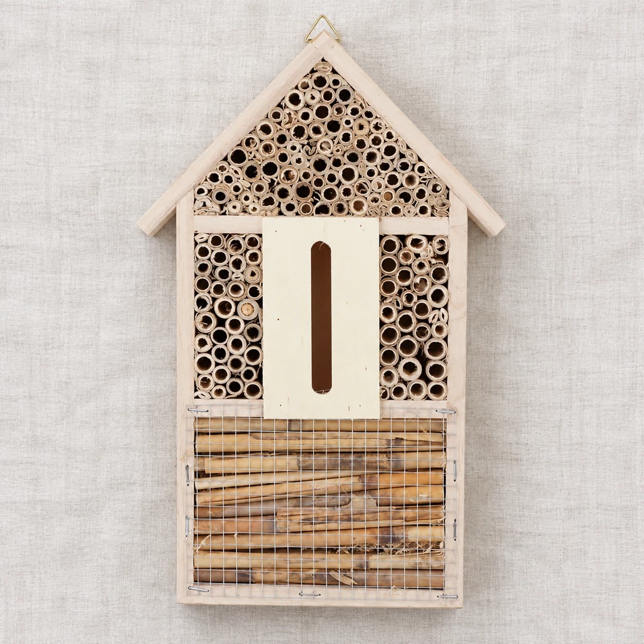Contenu du colis vu de dessus : une maisonnette à insectes posée à plat sur un linge clair
