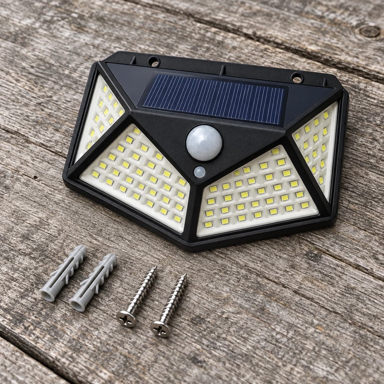 Applique solaire posée sur une table de jardin avec ses deux vis et ses deux chevilles