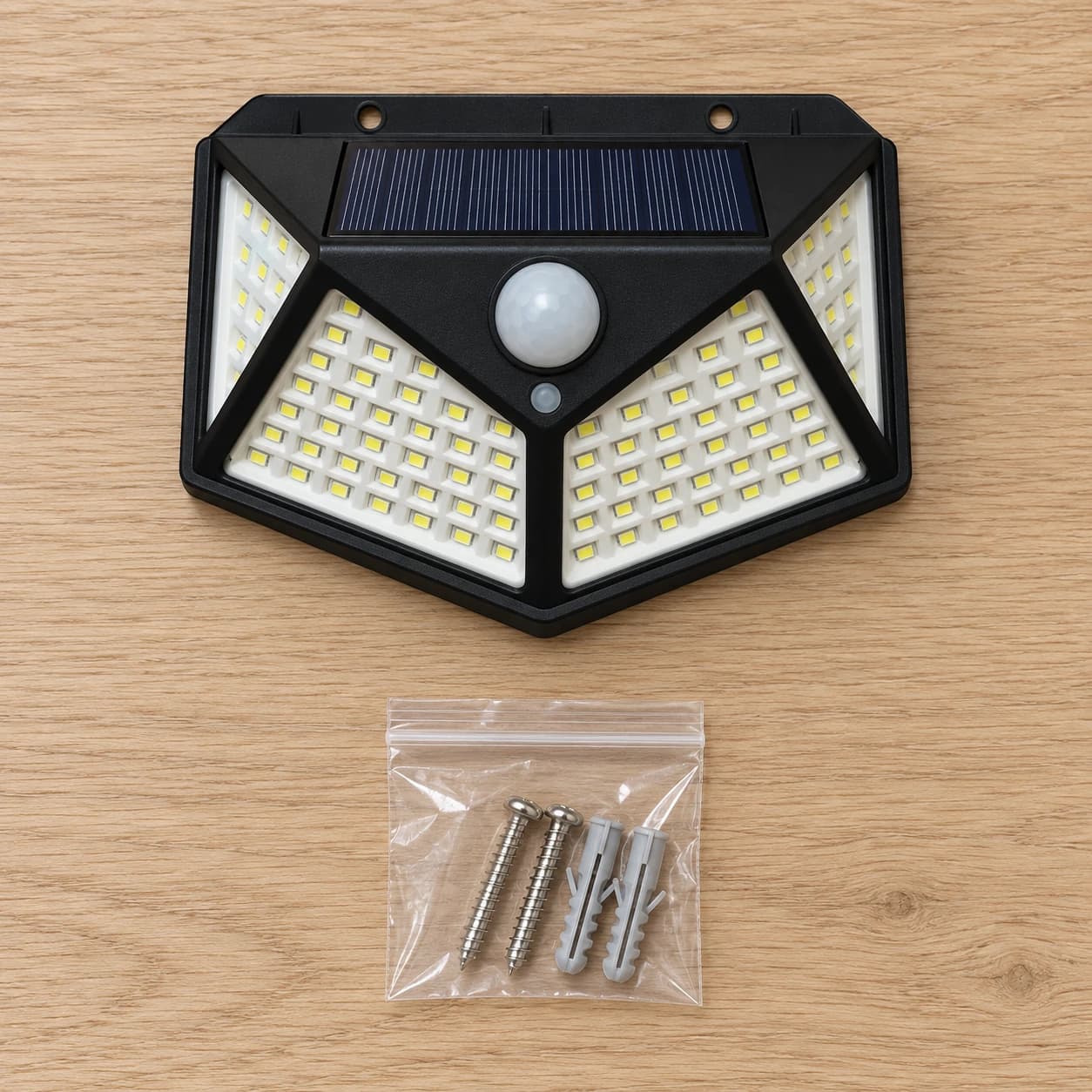 Contenu du colis : une applique solaire murale et son sachet de visserie de fixation