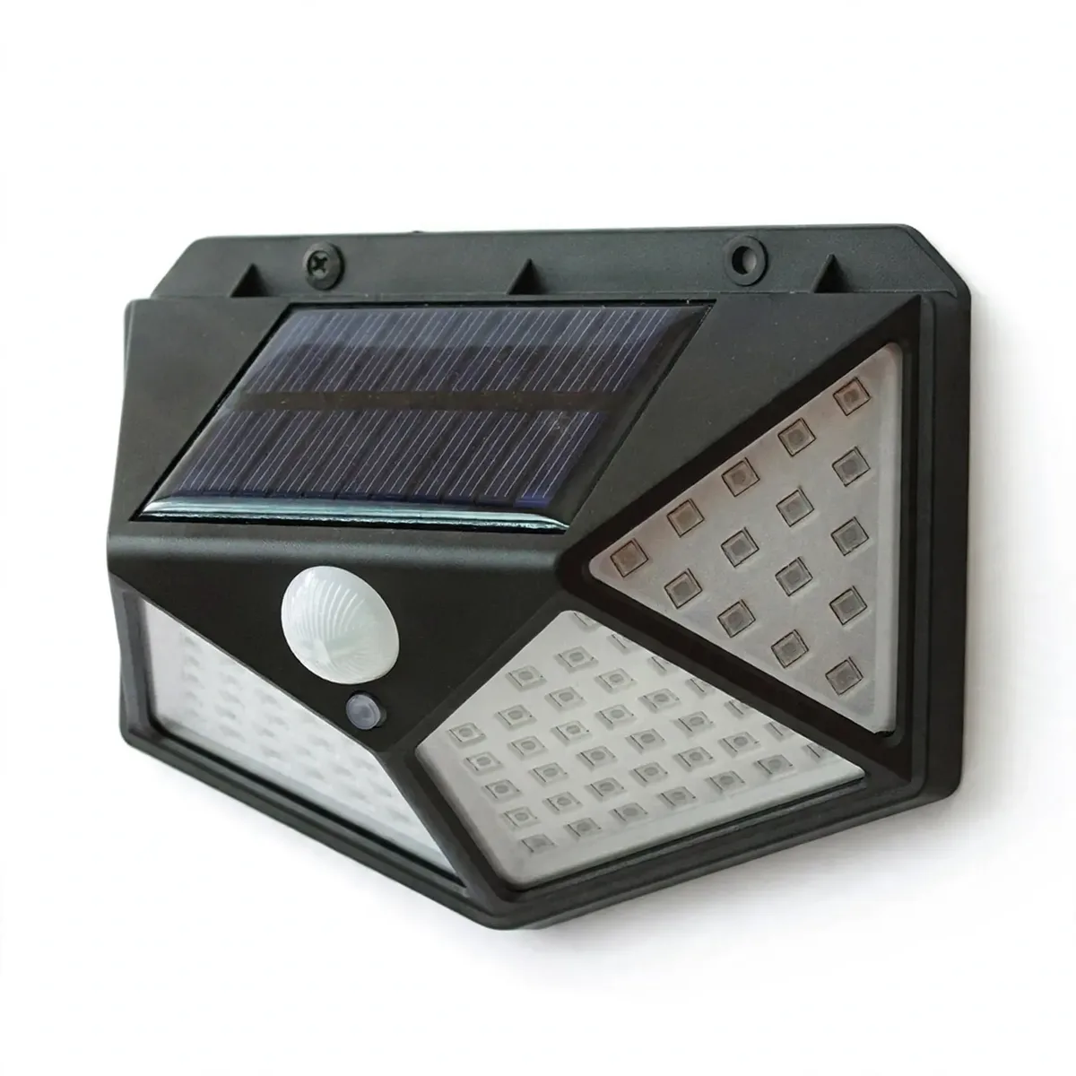 Sur fond blanc, applique solaire noire en trapèze à facettes, panneau sur la face supérieure inclinée, lentille ronde de détection et bouton en dessous