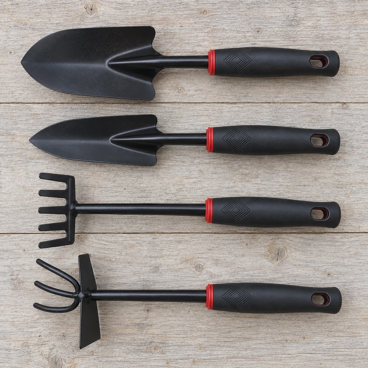 Le contenu du lot posé à plat en quatre rangées : pelle large, pelle étroite, râteau à cinq dents et houe