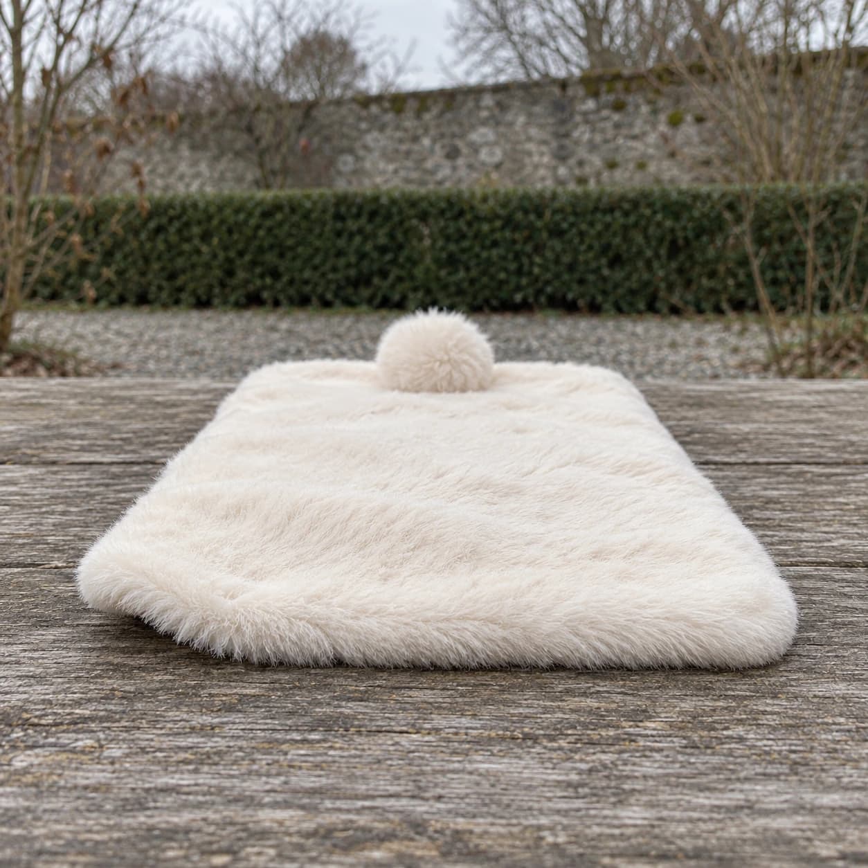 Le tapis polaire vu de profil sur une table en bois, épaisseur et poils longs