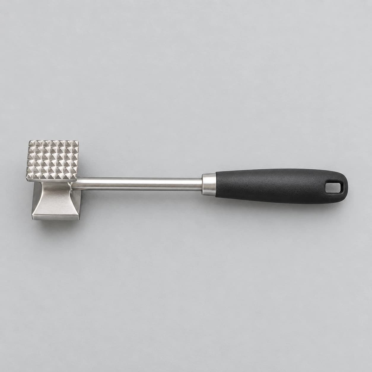 Contenu du colis vu de dessus, une seule pièce : le marteau à viande en inox mat face à picots vers le haut
