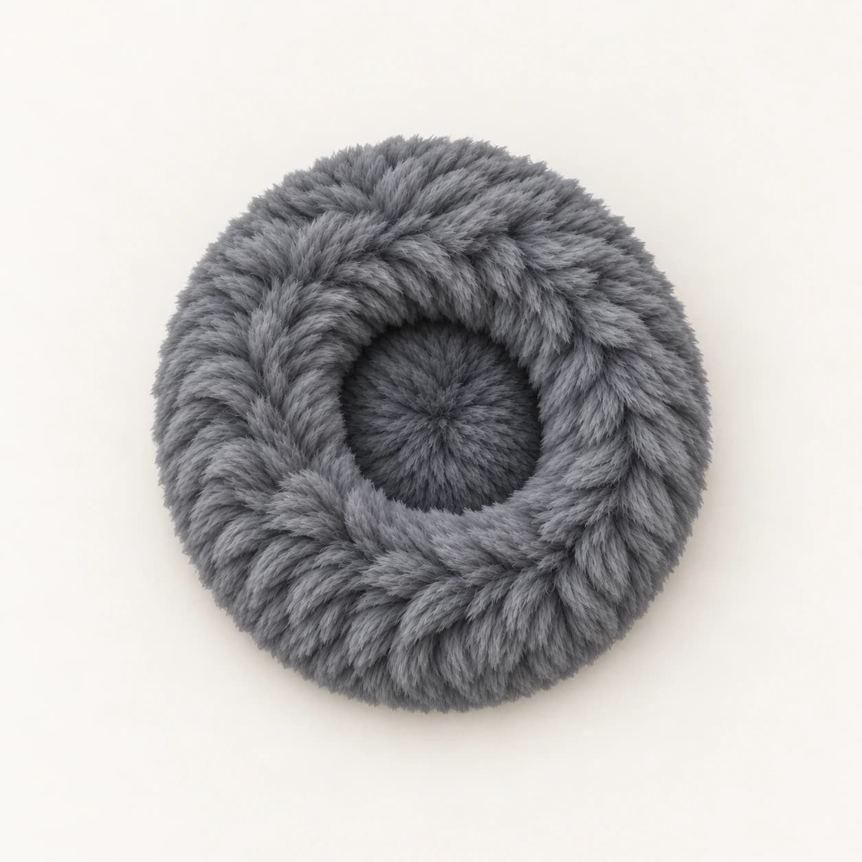 Nid rond en tissu gris à poils longs vu de dessus sur un fond clair, un seul article