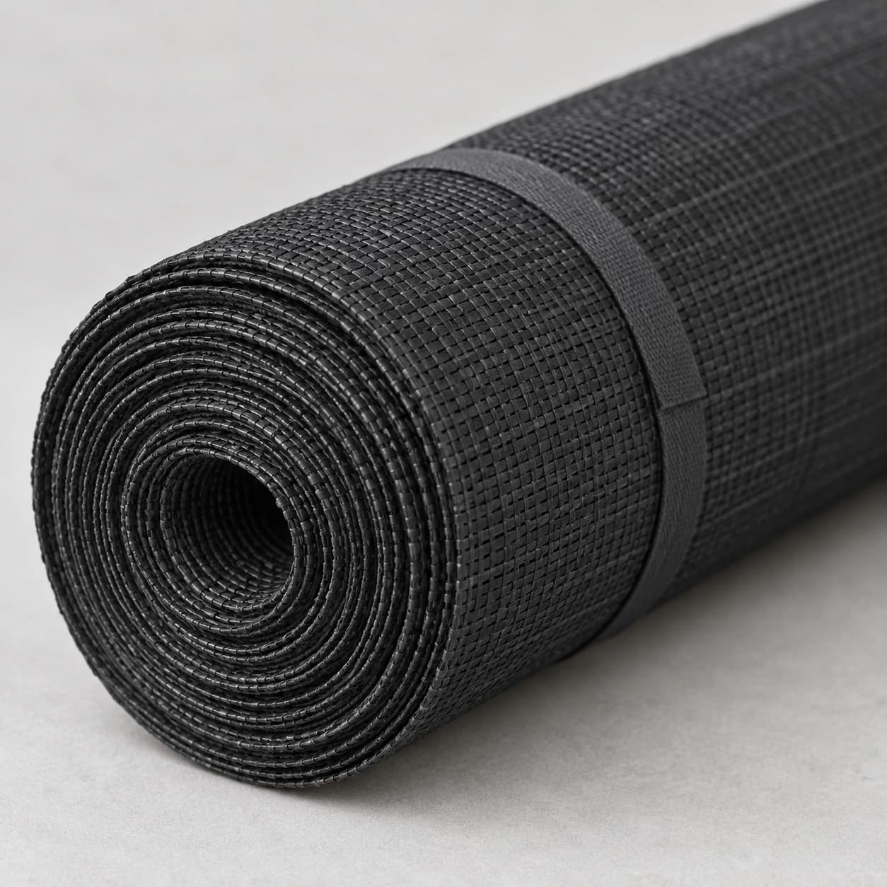 Paravent de balcon roulé en cylindre et serré par son lien textile, gros plan sur le bout du rouleau