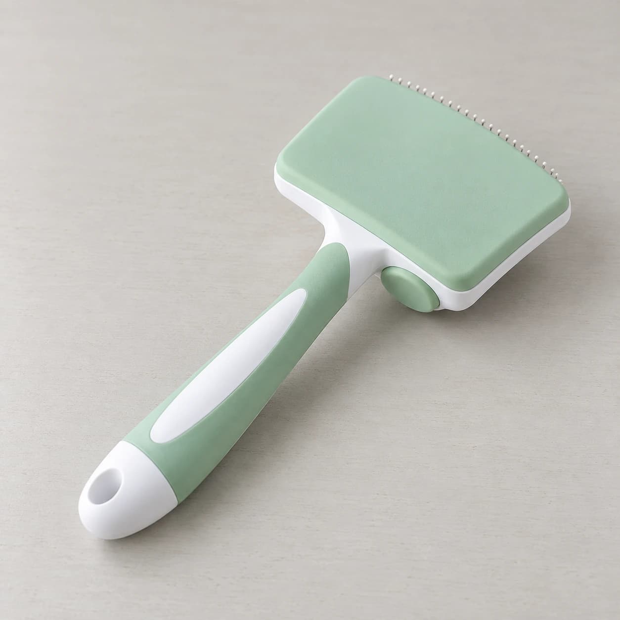 Dos de la tête de la brosse : liseré blanc du chariot, bouton vert, plaque de picots vide