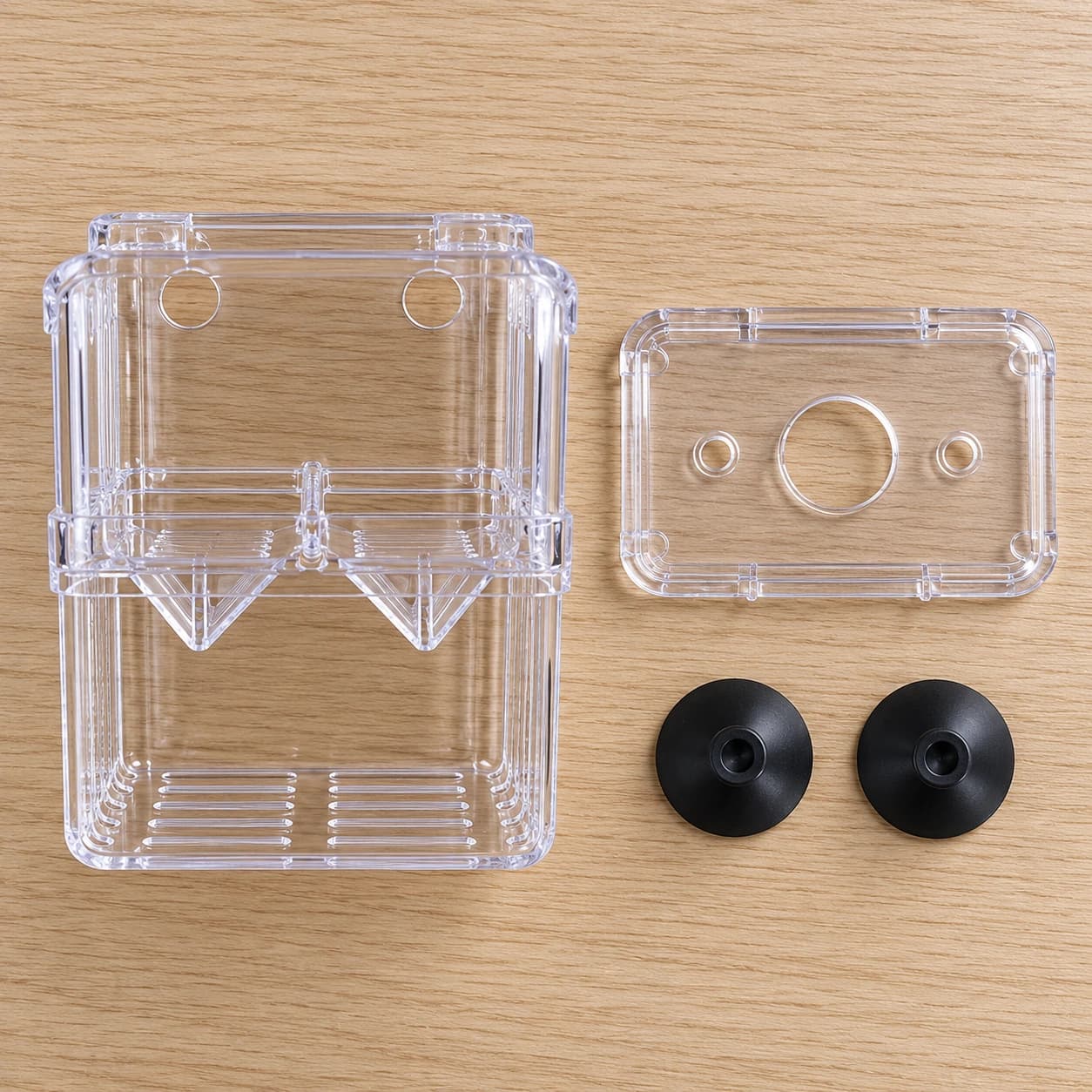 Le contenu du colis à plat : le caisson, le couvercle transparent et les deux ventouses noires