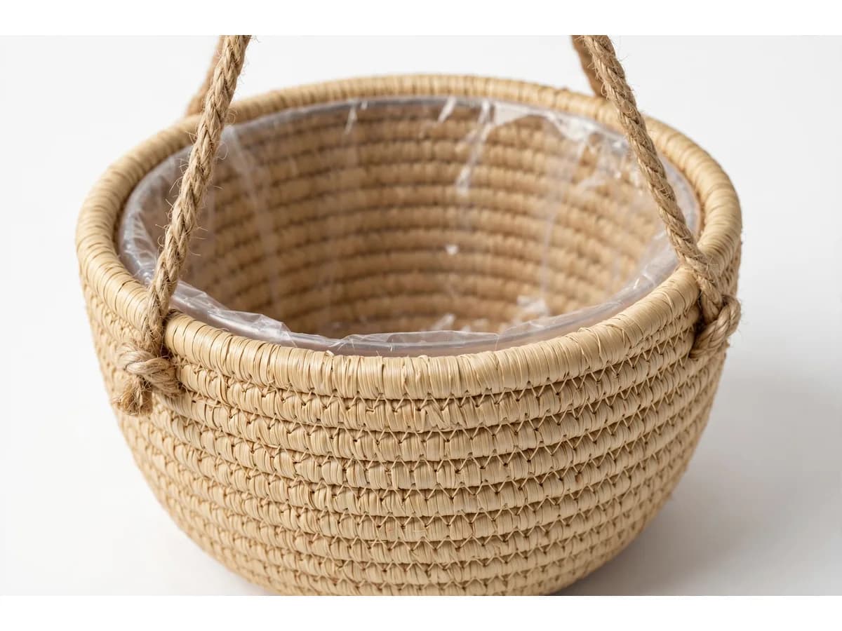 Gros plan du tressage en coils horizontaux serrés, une ficelle de coton nouée contre la paroi et le bord de la doublure translucide