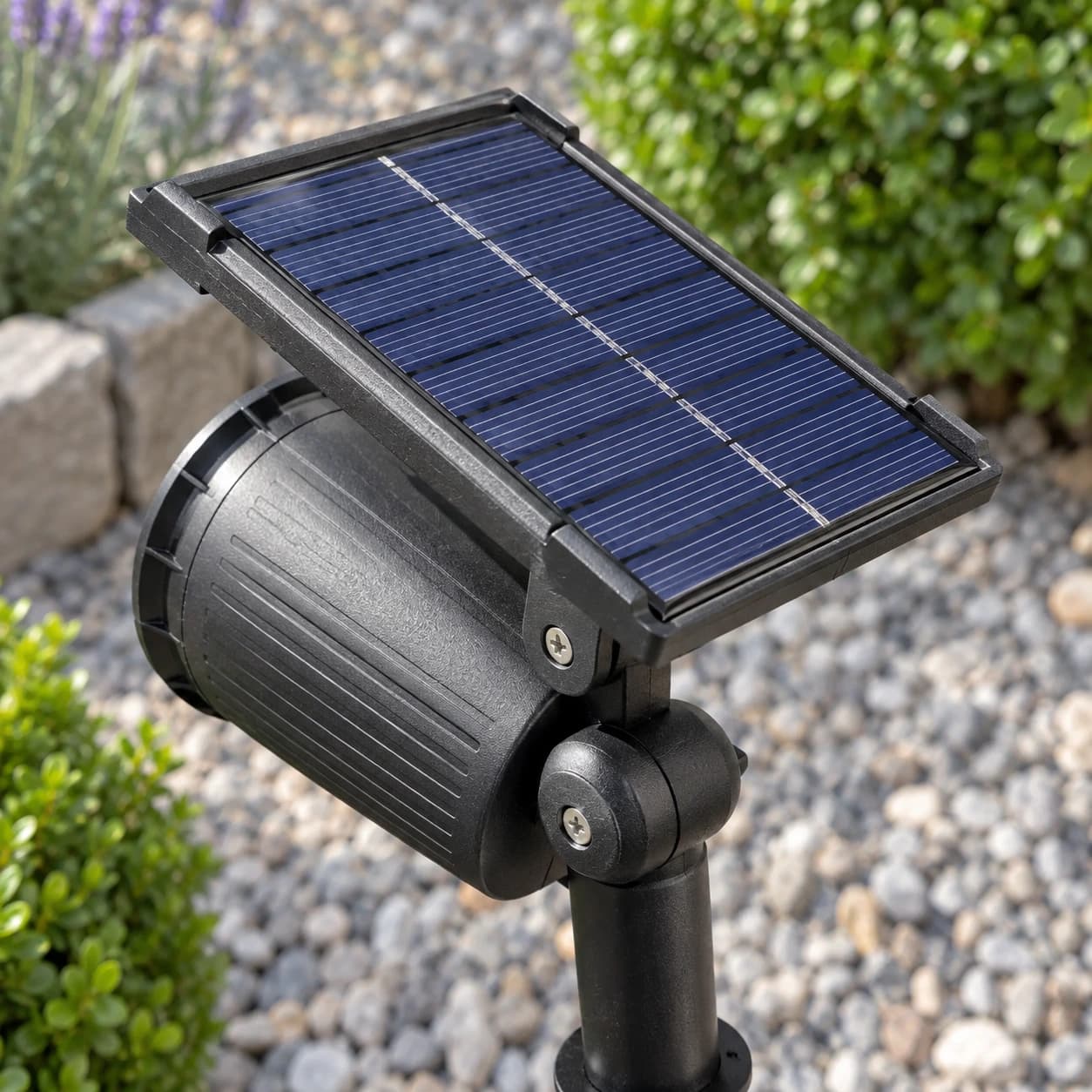 Détail du panneau solaire à cellules bleu sombre et de sa charnière vissée, au-dessus du barillet nervuré du projecteur