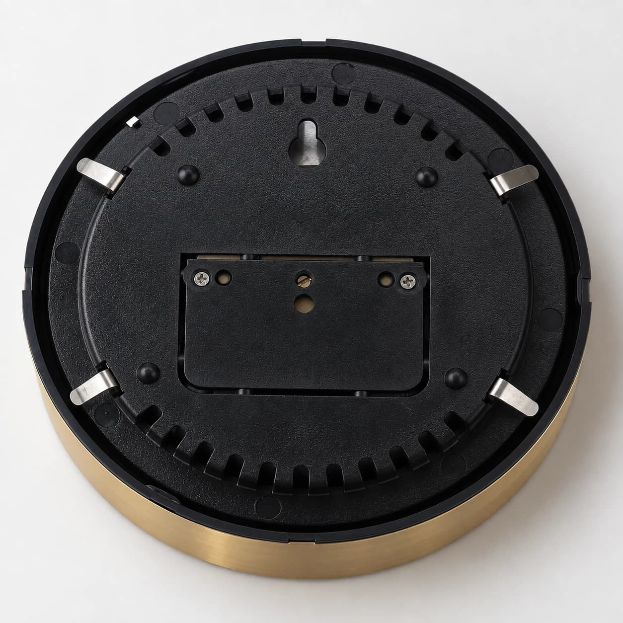 Dos du boîtier : coque noire, lumière en trou de serrure et quatre clips métalliques de fixation