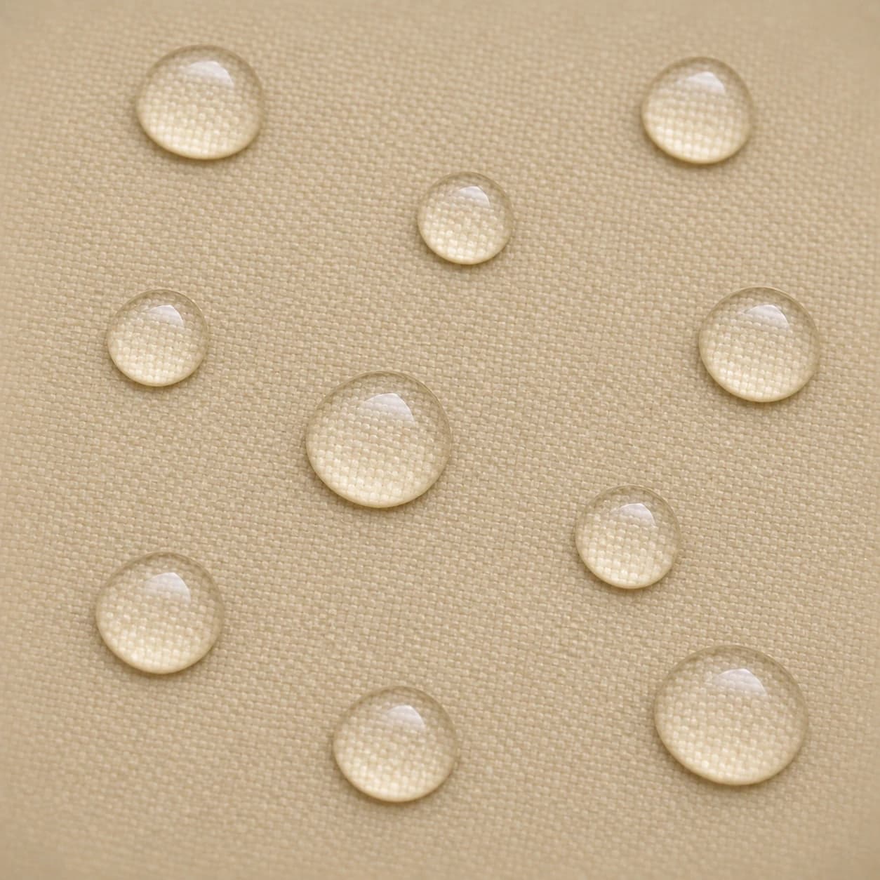 Macro du tissu polyester enduit beige, pluie fine perlant en surface.