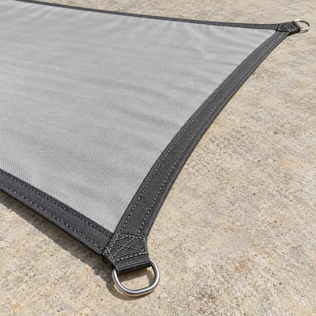 Voile pliée avec sa cordelette blanche et sa housse de rangement.