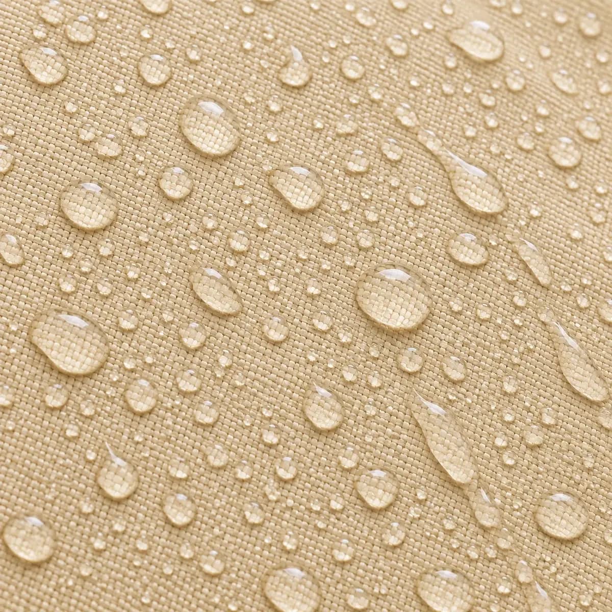 Perles d'eau sur l'enduction du polyester tissé jaune sable, après l'averse.