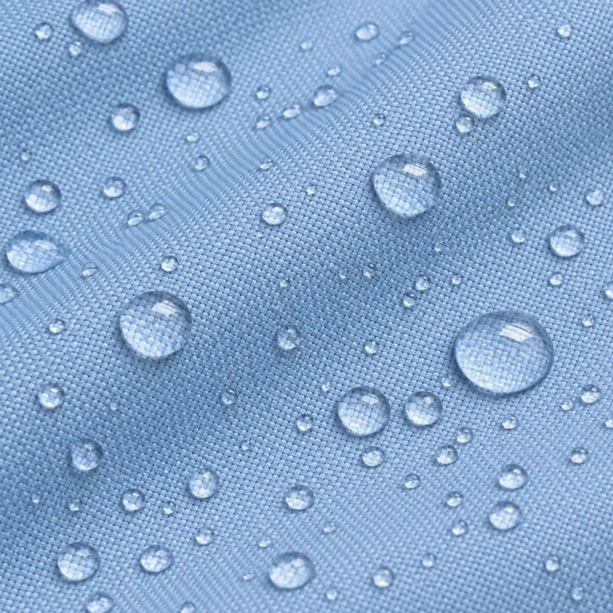 Macro du tissu enduit bleu ciel, gouttes d'eau perlant en surface.