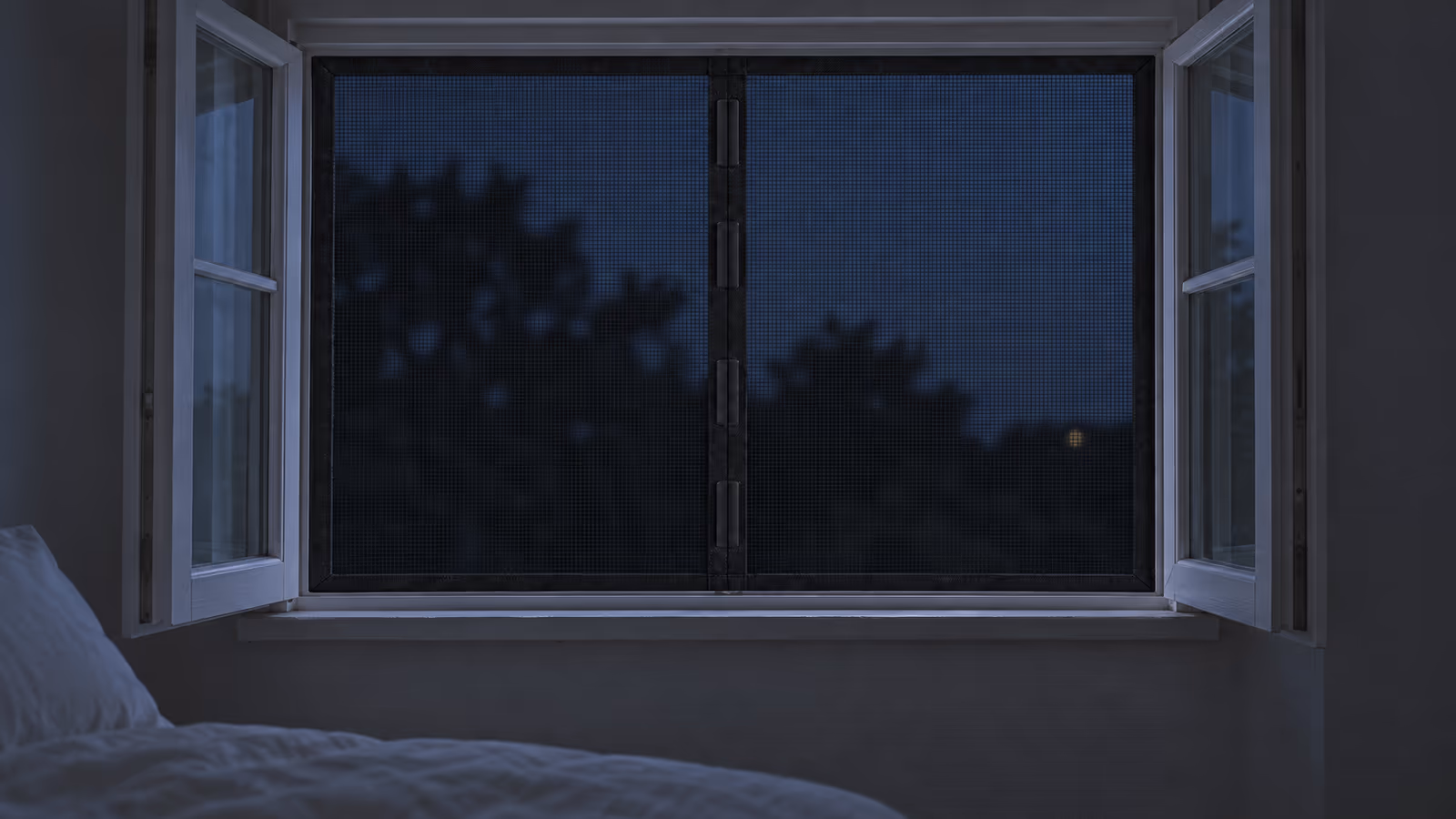 Chambre d'été la nuit, fenêtre ouverte sur un ciel sombre, rideau moustiquaire noir tendu sur le cadre blanc